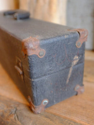 Alexander's rusty black suitcase