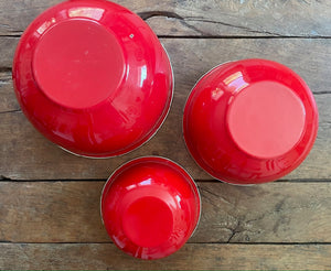 Set of bright red enamel bowls for kitchen decoration and use